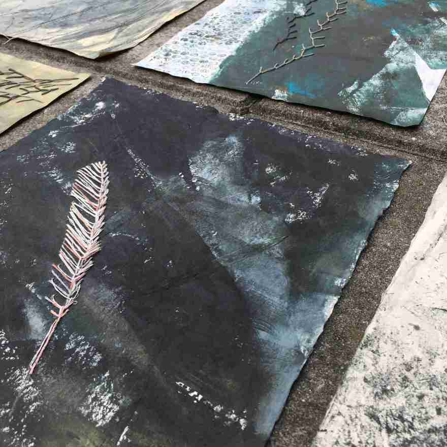 Feather on black sand beach